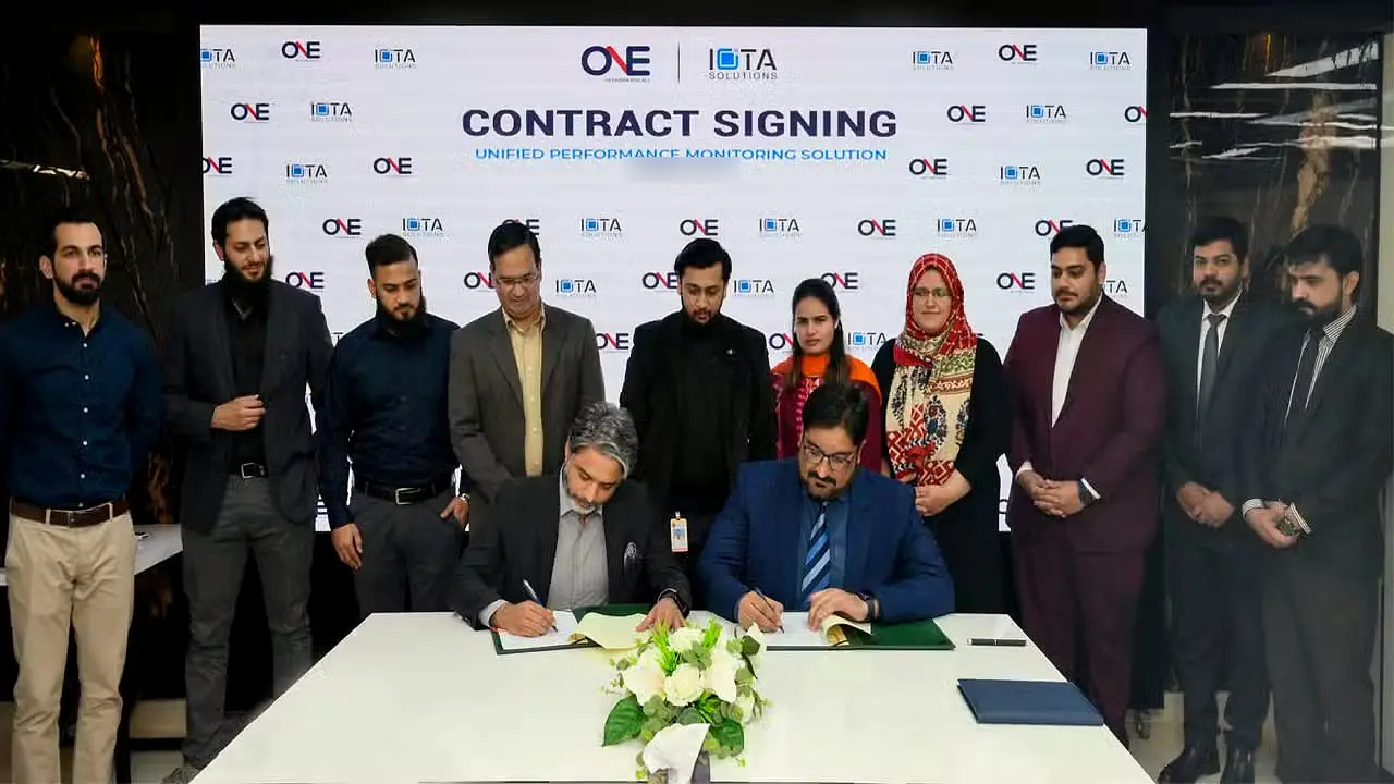 Usman standing with colleagues and guests at a contract signing