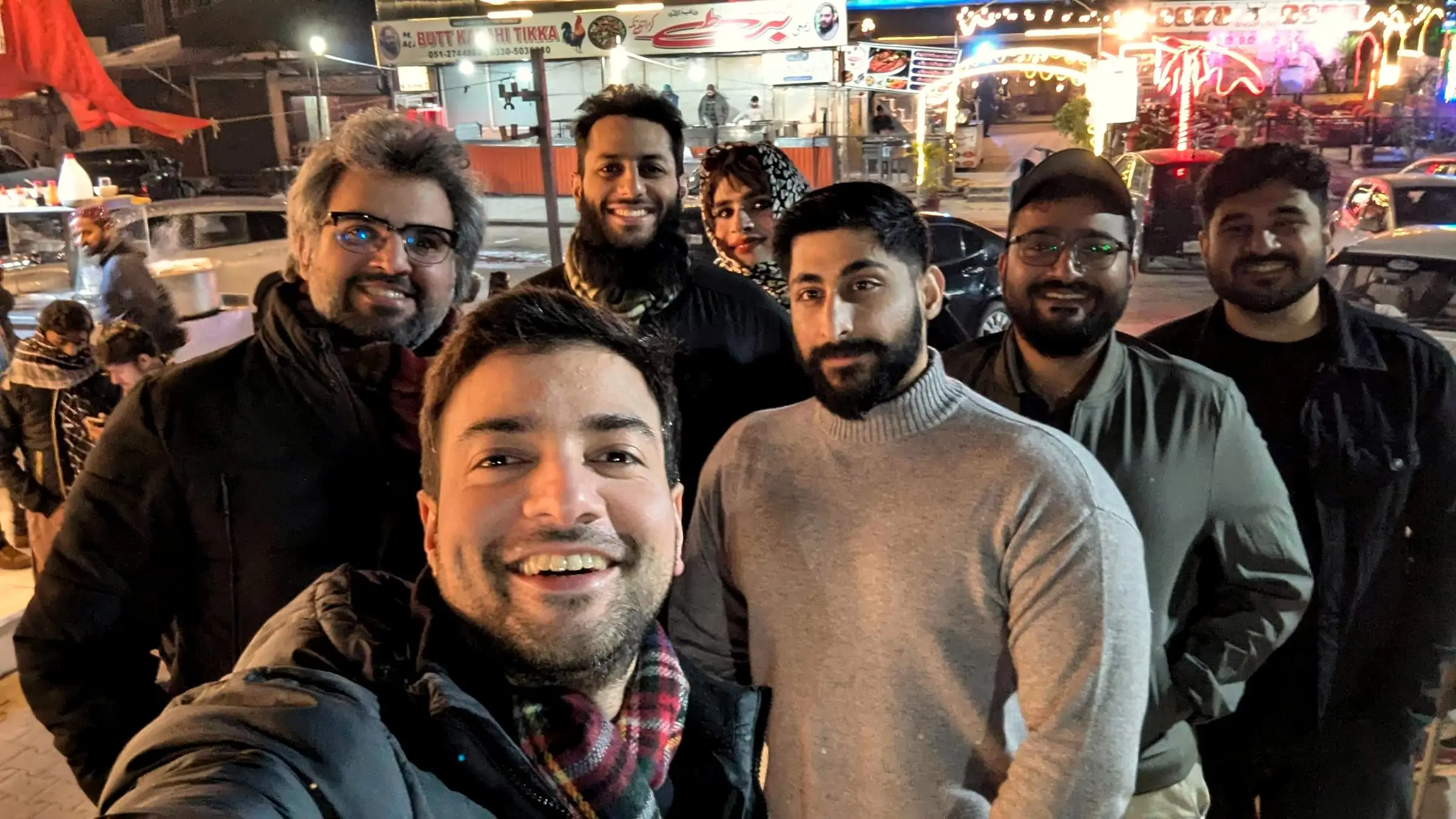 Usman with a startup team in a group selfie at night